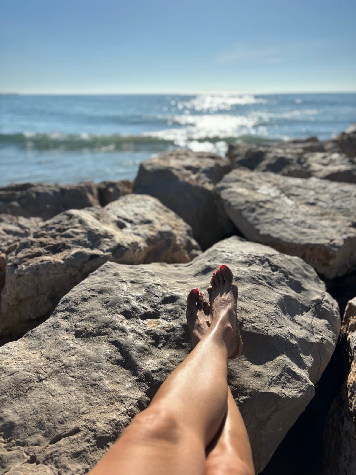 Füße auf Felsen am Meer, Katjas Blick beim Auswandern nach Spanien